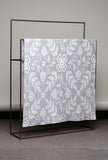 Floral patterned fabric on a black metal stand against a gray background