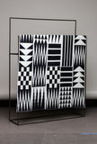 Black and white patterned fabric on a stand against a gray background