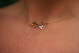 Gold necklace with a floral pendant on a person's neck