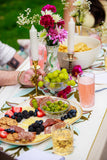 Dining table set with a plate of food, glasses, and flowers.