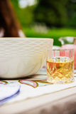 Glass of yellow liquid on a table with a blurred outdoor background
