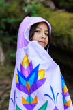 Person wearing a colorful towel with floral designs outdoors