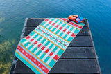 Colorful towel on a wooden dock by a body of water