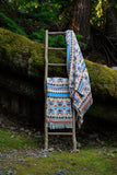 Blanket displayed outdoors on blanket ladder.