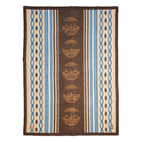 A square woven textile with a central vertical panel featuring five tan totem-style faces on a dark brown background, flanked by blue, beige, and brown striped bands with repeating geometric motifs.