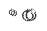 A pair of large silver-toned twisted hoop earrings with a textured, braided appearance, shown on a plain white background.