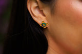 Close-up of an ear wearing a colorful star-shaped earring with blurred background
