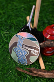 A circular magnet featuring an illustration of Snoqualmie Falls, styled on green grass alongside camping props including a red Coleman lantern, wooden sticks, and a black knit bag.