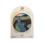 Magnet of Snoqualmie Falls, Washington, displayed on its original arched backing card. The pin features a stylized landscape with blue water, green hills, and brown land, with 'Snoqualmie Falls' written in black script.